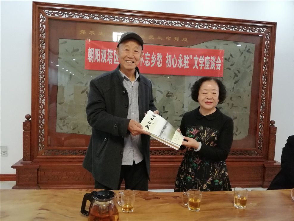 双塔区作协主席周艳丽向双塔区文艺家协会主席许永志赠送《燕都文艺》